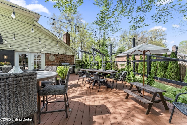 wooden deck featuring french doors and outdoor dining space