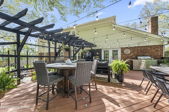 wooden deck featuring a pergola, a grill, and outdoor dining space