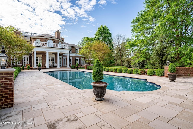 outdoor pool featuring french doors and a patio area