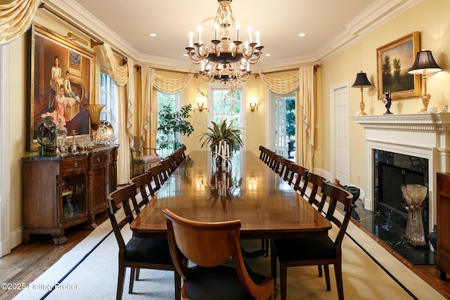 dining area with wood finished floors, a chandelier, ornamental molding, recessed lighting, and a premium fireplace