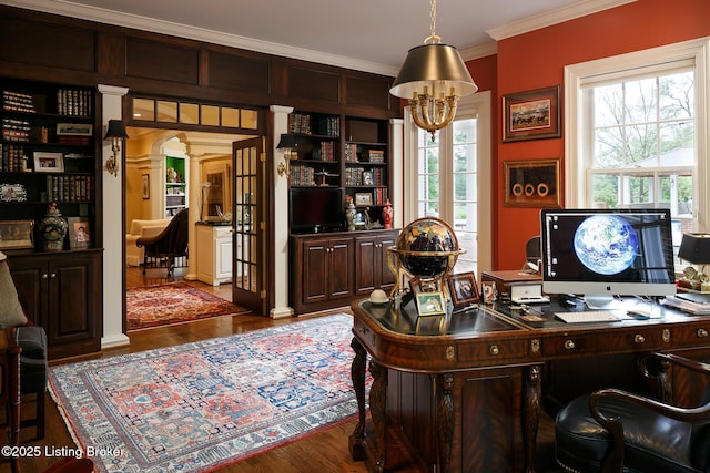 home office with crown molding, decorative columns, and wood finished floors
