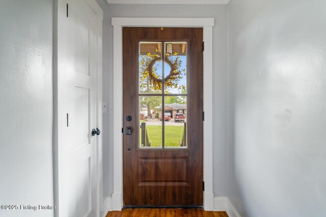 entryway featuring baseboards and wood finished floors