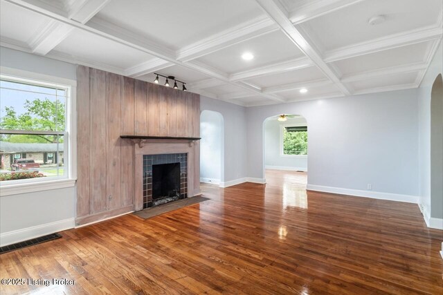 unfurnished living room featuring visible vents, arched walkways, baseboards, dark wood-style floors, and coffered ceiling