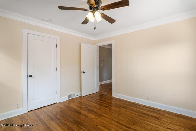 unfurnished bedroom featuring crown molding, baseboards, visible vents, and wood finished floors
