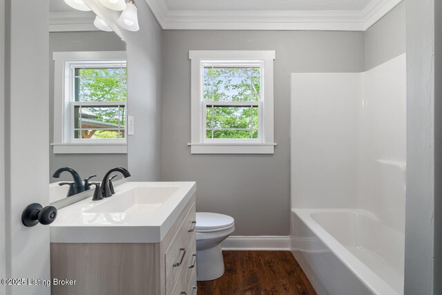 bathroom with vanity, plenty of natural light, crown molding, and toilet
