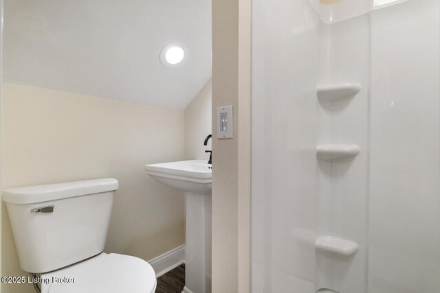 full bath featuring toilet, baseboards, wood finished floors, lofted ceiling, and a shower