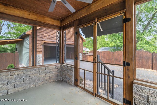 unfurnished sunroom featuring a ceiling fan