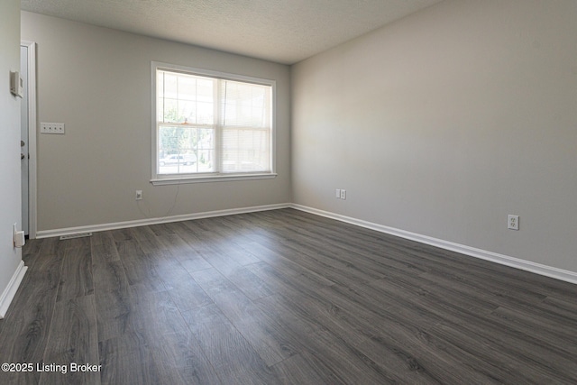 unfurnished room with baseboards, dark wood-style floors, and a textured ceiling