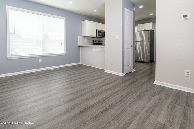 kitchen featuring recessed lighting, stainless steel appliances, dark wood-style flooring, and white cabinetry