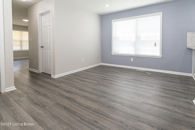 unfurnished room with baseboards and a wealth of natural light