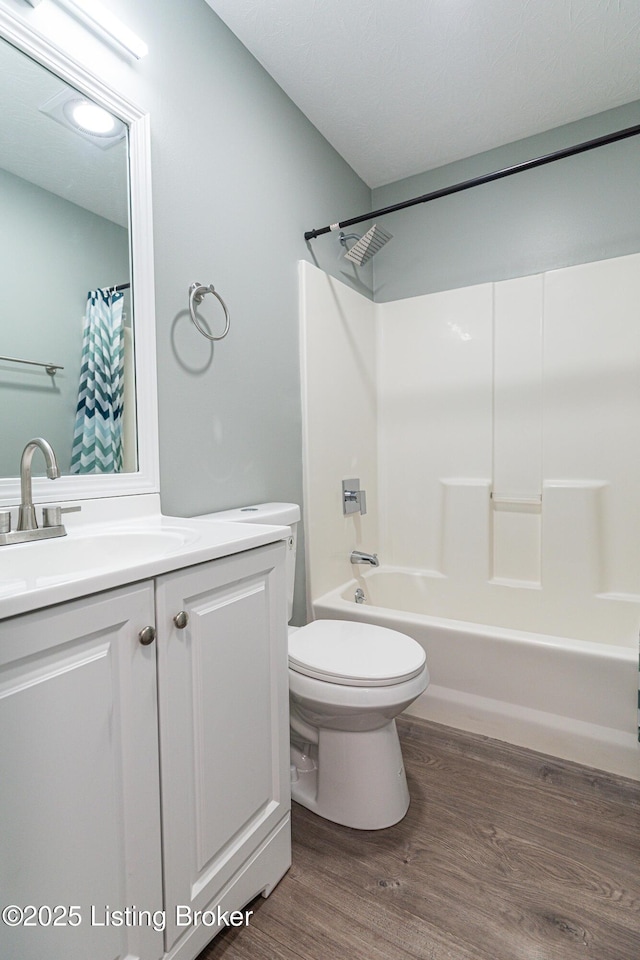 full bath with vanity, wood finished floors, shower / bath combination with curtain, and toilet