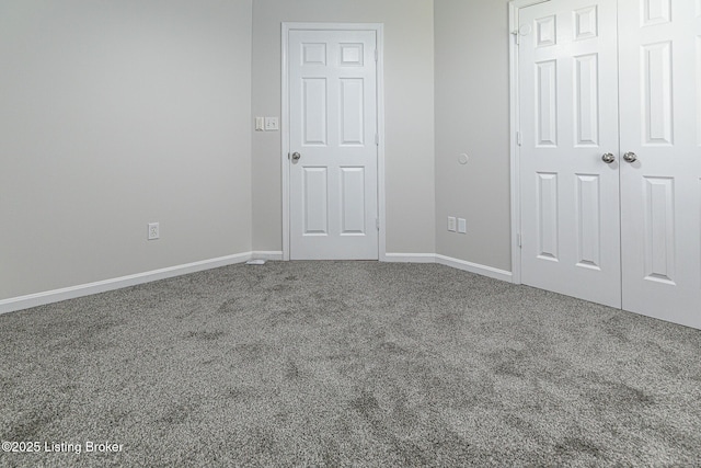 unfurnished bedroom featuring baseboards, carpet, and a closet