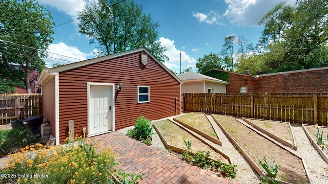 1223 S 1st St, Louisville, KY 40203 - view of outbuilding with a vegetable garden, a fenced backyard, and an outbuilding