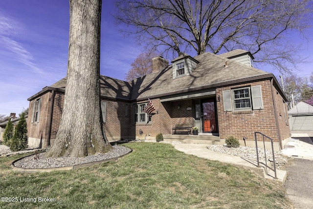 view of front of property with roof with shingles, a chimney, a front lawn, and brick siding