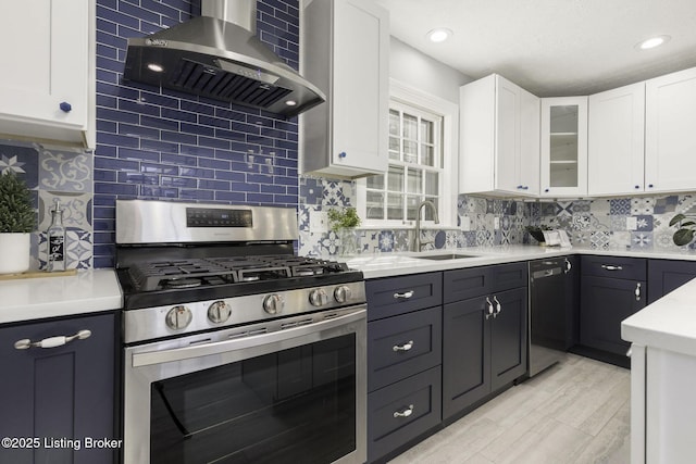 kitchen with gas stove, dishwashing machine, wall chimney exhaust hood, and white cabinetry