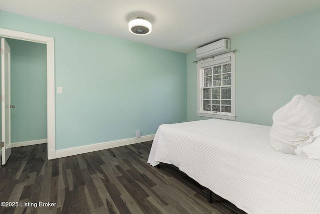 bedroom featuring an AC wall unit, dark wood-style flooring, and baseboards