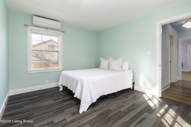bedroom featuring baseboards, a wall mounted AC, and dark wood finished floors