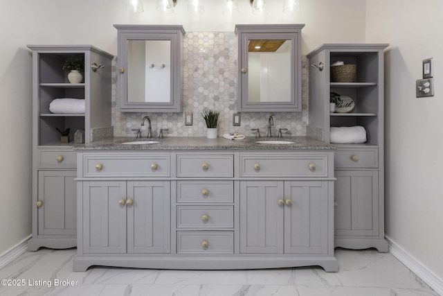 bathroom with baseboards, a sink, and marble finish floor
