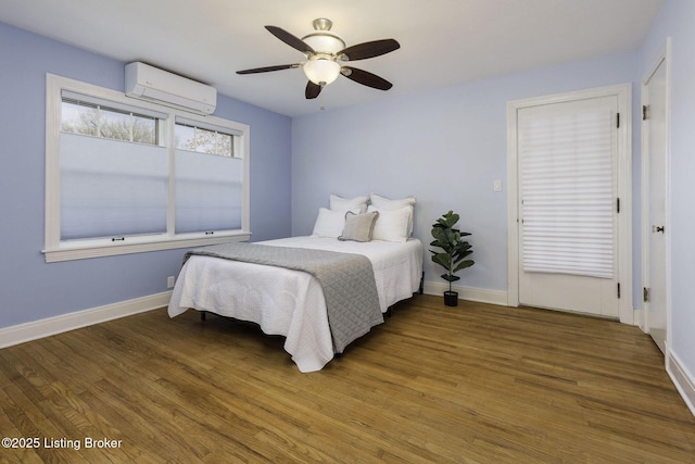 bedroom with baseboards, a wall mounted AC, a ceiling fan, and wood finished floors