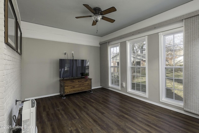 unfurnished living room with heating unit, baseboards, ceiling fan, and wood finished floors