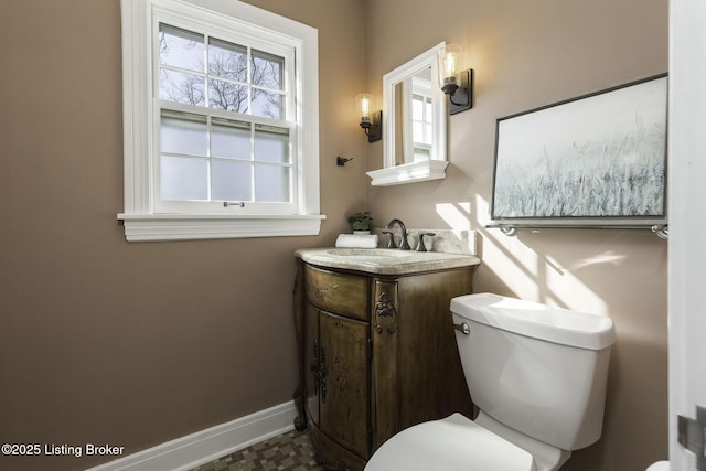 bathroom with baseboards, toilet, and vanity
