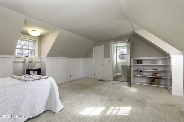 carpeted bedroom featuring vaulted ceiling and multiple windows
