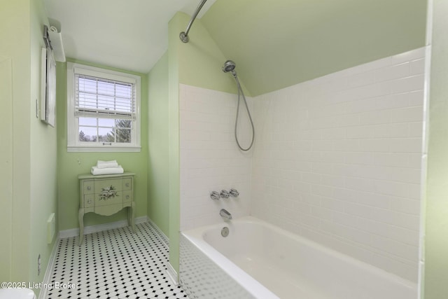 bathroom featuring shower / bath combination, baseboards, and lofted ceiling