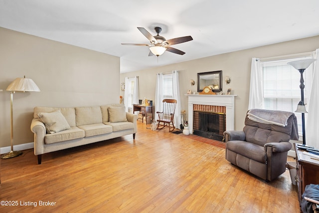 1042 Parkway Dr, Louisville, KY 40217 - living area with light wood-type flooring, a ceiling fan, baseboards, and a brick fireplace