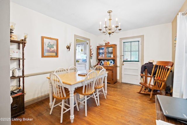 1042 Parkway Dr, Louisville, KY 40217 - dining area with baseboards, light wood finished floors, and a notable chandelier