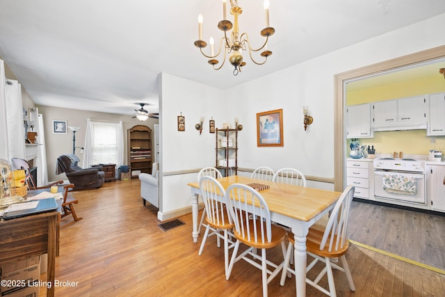 1042 Parkway Dr, Louisville, KY 40217 - dining room featuring visible vents, light wood-style floors, and ceiling fan with notable chandelier