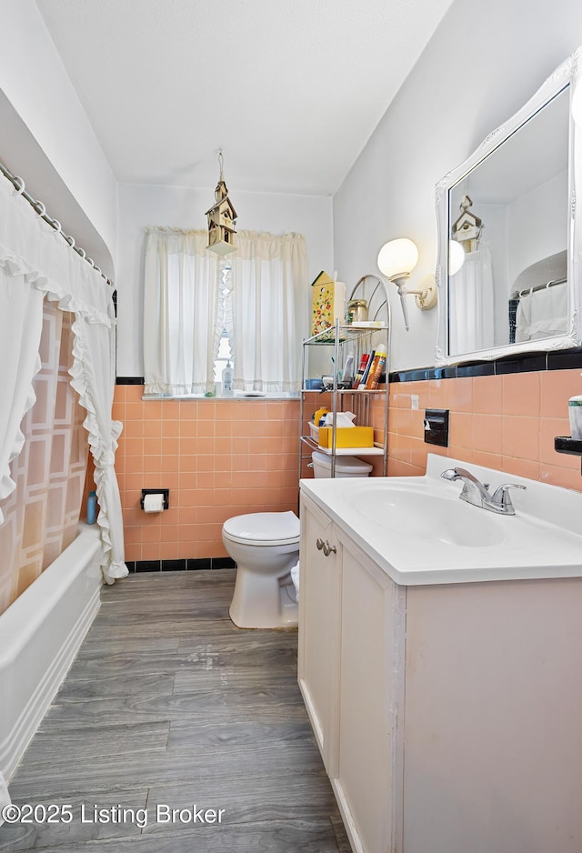 1042 Parkway Dr, Louisville, KY 40217 - bathroom featuring toilet, tile walls, wood finished floors, and vanity