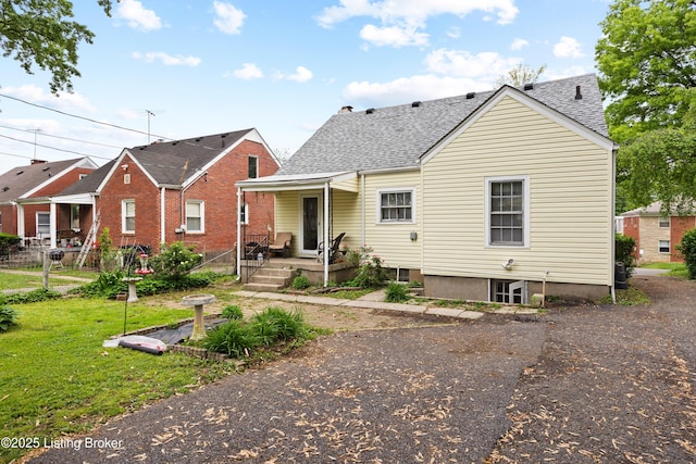 1042 Parkway Dr, Louisville, KY 40217 - rear view of property featuring a lawn, fence, a shingled roof, and a chimney