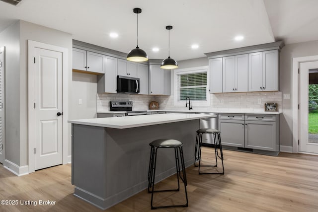 1614 W Reel Dr, La Grange, KY 40031 - kitchen with appliances with stainless steel finishes, gray cabinets, decorative backsplash, light wood-type flooring, and recessed lighting
