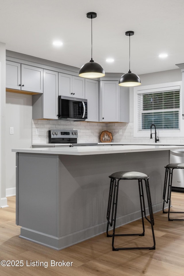 1614 W Reel Dr, La Grange, KY 40031 - kitchen featuring stainless steel appliances, light wood-style floors, decorative backsplash, gray cabinetry, and recessed lighting