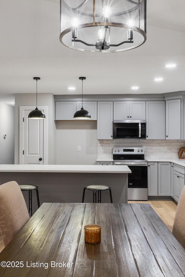 1614 W Reel Dr, La Grange, KY 40031 - kitchen featuring stainless steel appliances, gray cabinets, backsplash, and decorative light fixtures