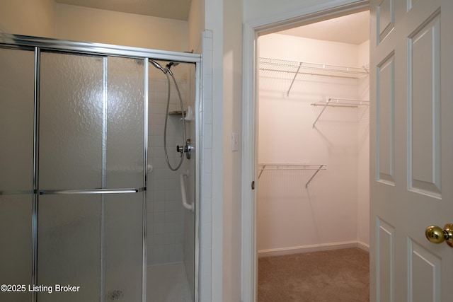 full bathroom with a spacious closet and a shower stall