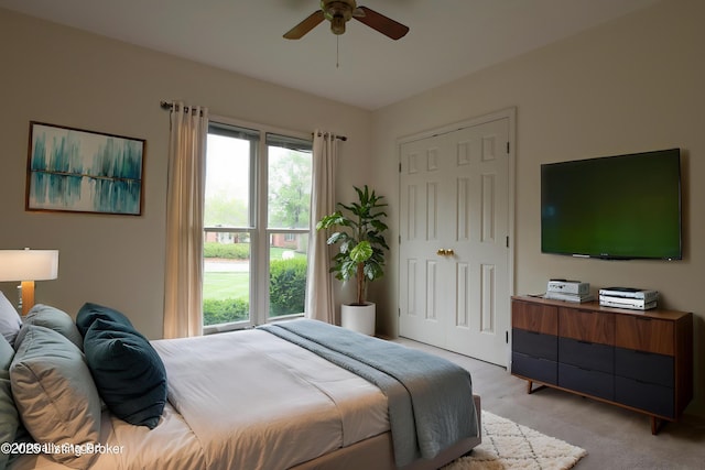 bedroom with ceiling fan, a closet, and light colored carpet