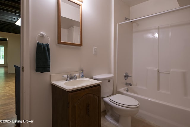 bathroom with toilet,  shower combination, wood finished floors, and vanity
