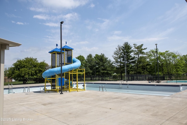 exterior space with a water play area, a water slide, playground community, and fence