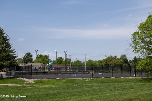 view of sport court featuring a yard, fence, and playground community