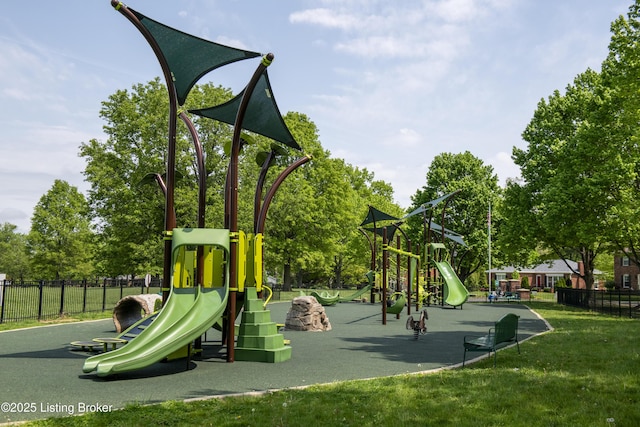communal playground featuring a lawn and fence