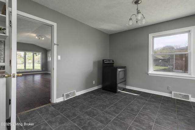 spare room with visible vents, a textured ceiling, and vaulted ceiling
