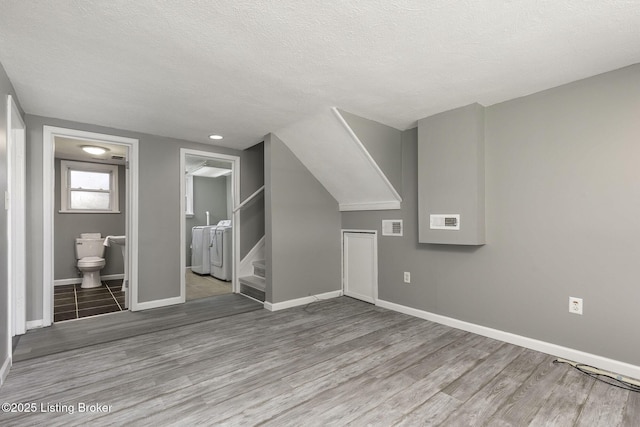 bonus room featuring a textured ceiling, visible vents, wood finished floors, stairway, and baseboards