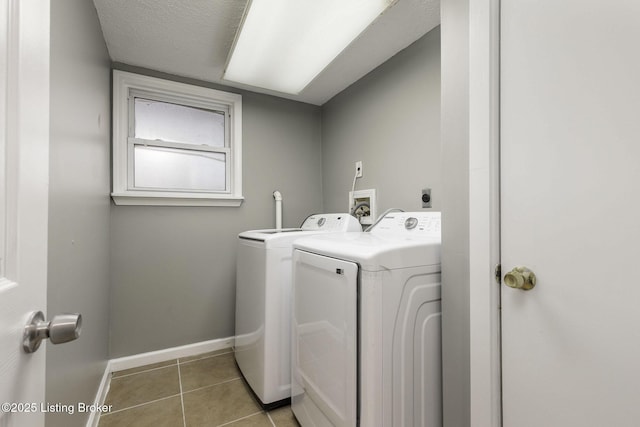 laundry area featuring washer and dryer, light tile patterned flooring, laundry area, and baseboards
