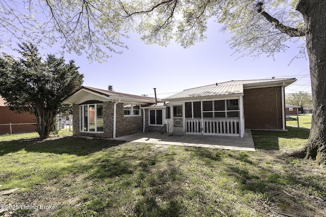 back of house featuring a patio area, a sunroom, brick siding, fence, and a yard