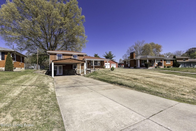 split level home featuring covered porch, driveway, french doors, and a front yard