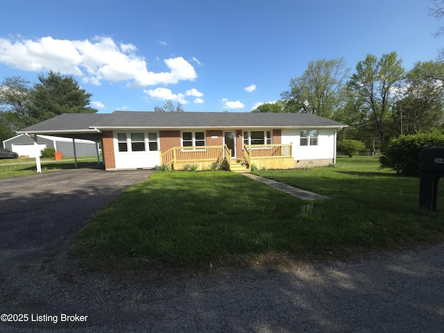 ranch-style home featuring covered porch, a front yard, brick siding, aphalt driveway, and an attached carport