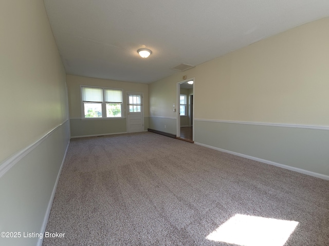 empty room with baseboards, carpet, and visible vents