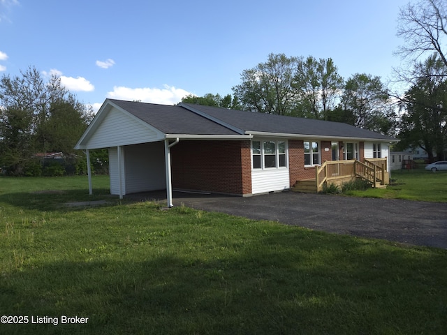single story home with a front yard, brick siding, and aphalt driveway