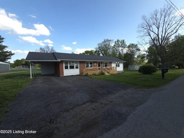 single story home with a carport, a front lawn, and aphalt driveway